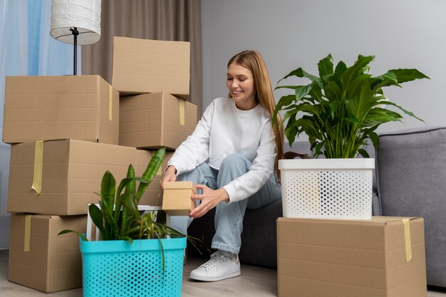 Mujer manejando pertenencias después de mudarse a una casa nueva