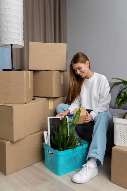 Mujer manejando pertenencias después de mudarse a una casa nueva