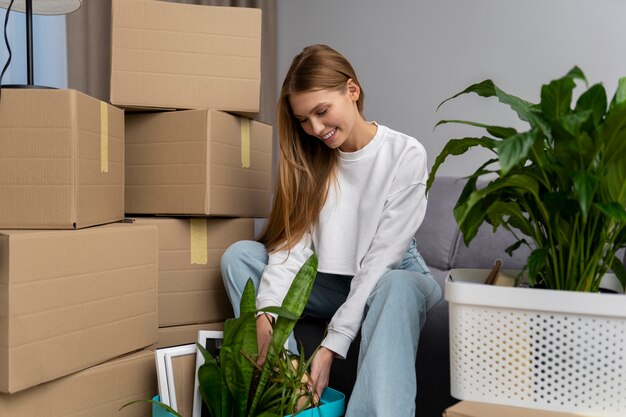 Mujer manejando pertenencias después de mudarse a una casa nueva