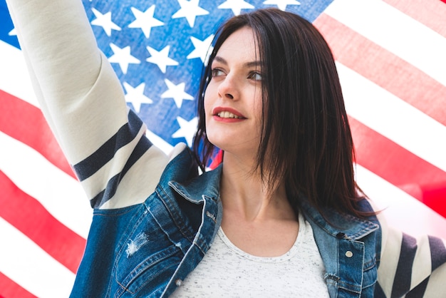 Foto gratuita mujer con la mano arriba y la bandera estrellada