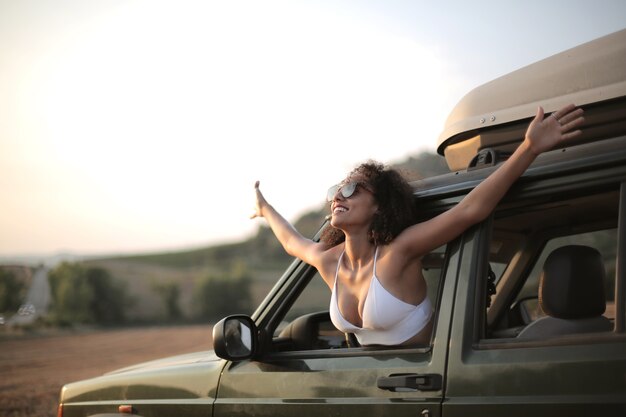 Mujer con las manos abiertas mirando por la ventanilla del coche