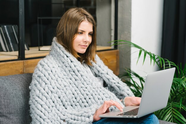 Mujer en manta usando laptop