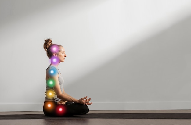 Foto gratuita mujer manteniendo asana mientras los puntos de los chakras están alineados