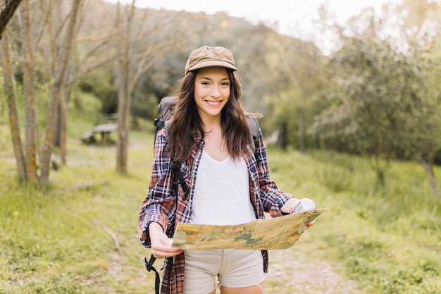 Mujer con mapa caminando en el camino