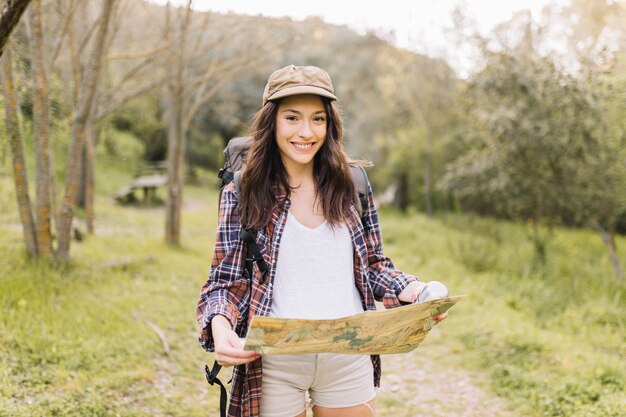 Mujer con mapa caminando en el camino