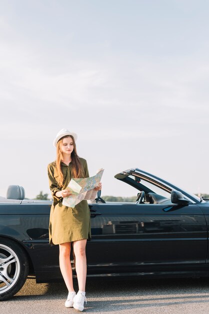 Mujer con mapa cerca de cabriolet