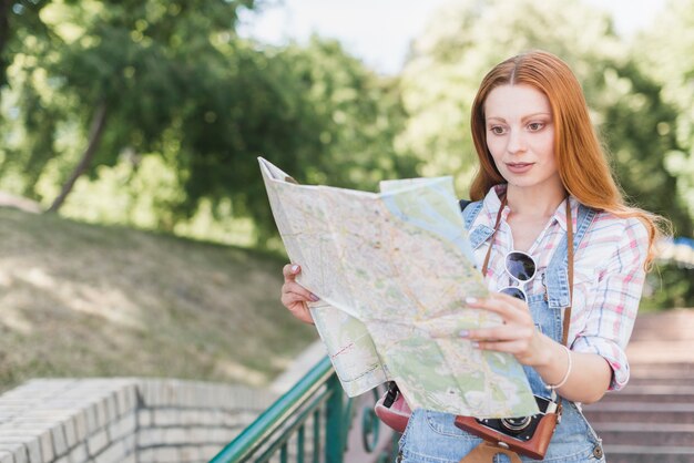 Mujer con mapa de la ciudad en el parque