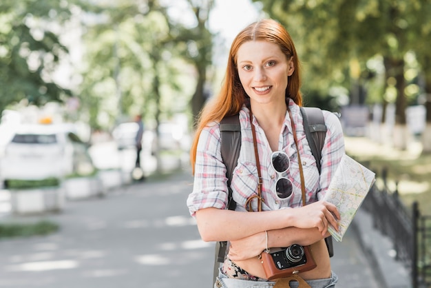 Foto gratuita mujer con mapa de mochila y cámara