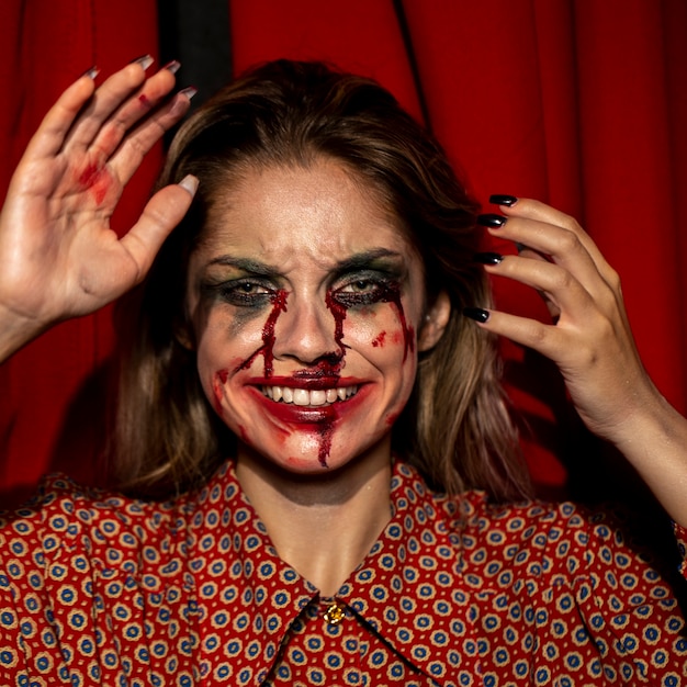 Mujer con maquillaje de joker de halloween sonríe con sus dientes