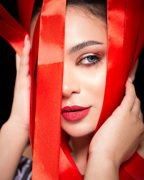 Mujer en maquillaje rojo con cinta roja