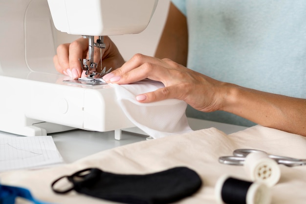 Mujer con máquina de coser para mascarilla