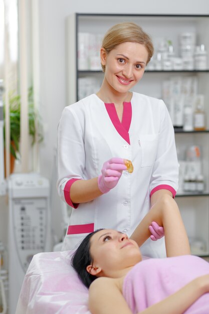 Mujer con una masa naranja entre los dedos