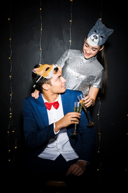 Foto gratuita mujer con máscara de gato abrazando a hombre con máscara de zorro y gafas pegadas