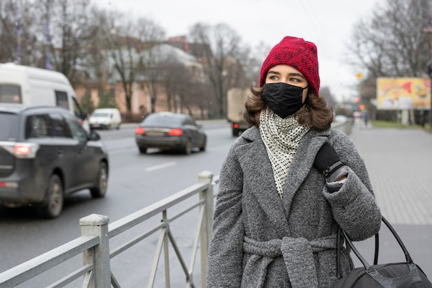 Mujer con máscara médica al aire libre en la ciudad