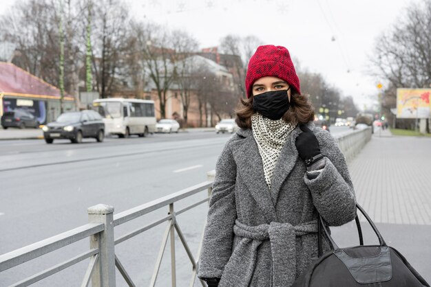 Mujer con máscara médica caminando al aire libre