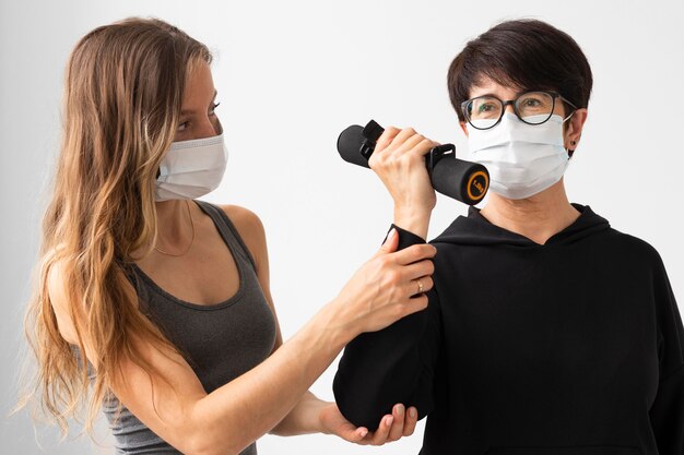 Mujer con máscara médica recuperándose del coronavirus