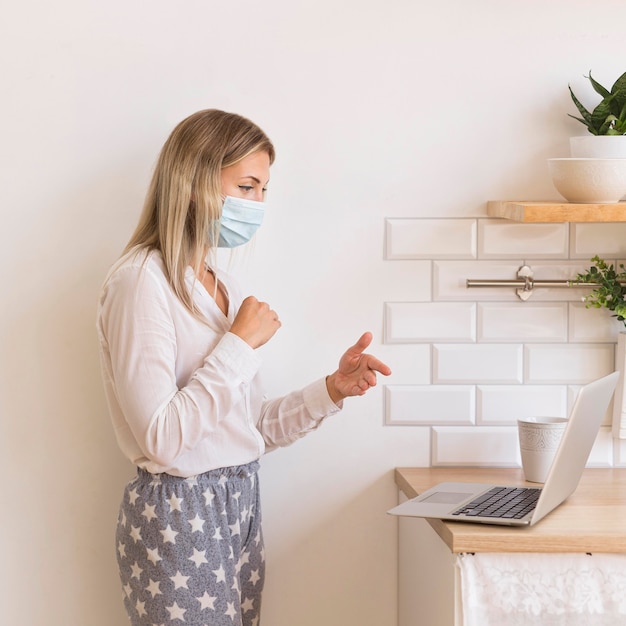 Foto gratuita mujer con máscara trabajando desde casa