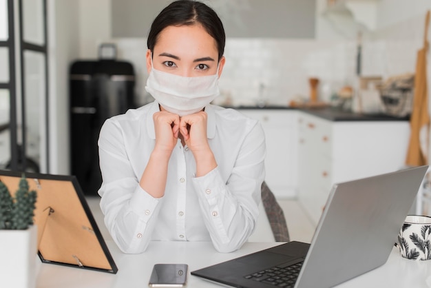 Foto gratuita mujer con máscara trabajando