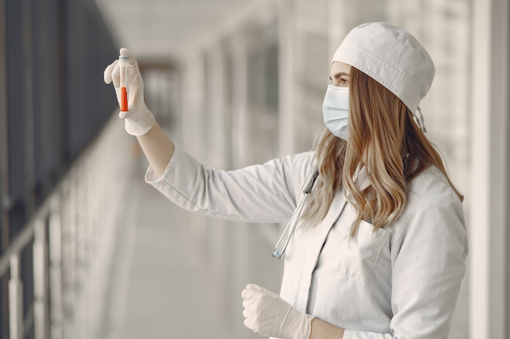 Foto gratuito mujer en una máscara y uniforme sosteniendo un tubo en sus manos