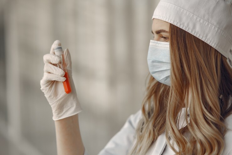 Foto gratuito mujer en una máscara y uniforme sosteniendo un tubo en sus manos