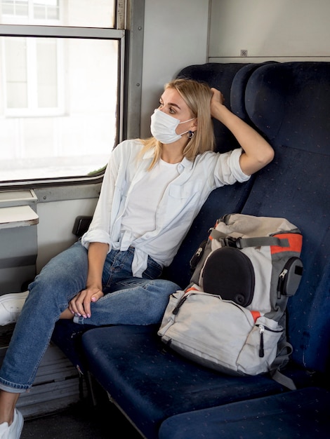 Mujer con máscara viajando en tren