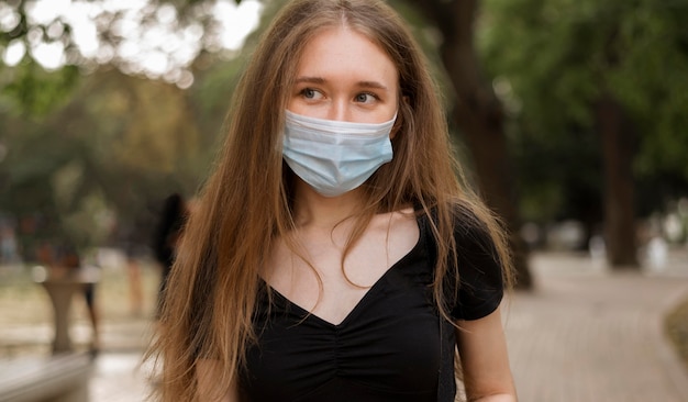 Mujer con mascarilla caminando en el parque