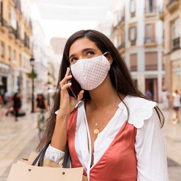 Mujer con mascarilla hablando por teléfono