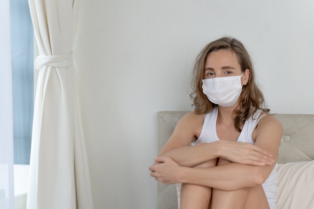 Foto gratuita mujer con mascarilla para protegerse la sensación de dolor de cabeza y tos debido al coronavirus covid-19 en la sala de cuarentena