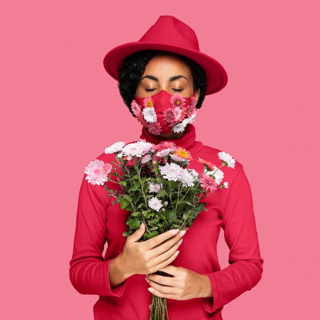 Mujer con mascarilla sosteniendo un color de ramo del año 2023