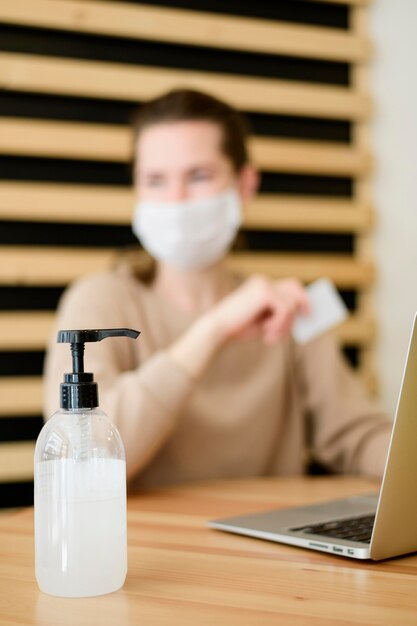 Foto gratuita mujer con mascarilla con tarjeta de crédito