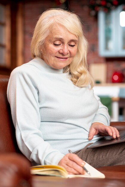 Mujer mayor de alto ángulo tomando notas