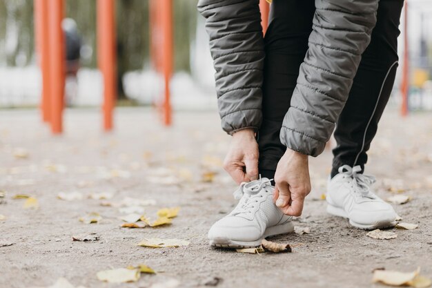 Mujer mayor atar sus cordones antes de hacer ejercicio con espacio de copia