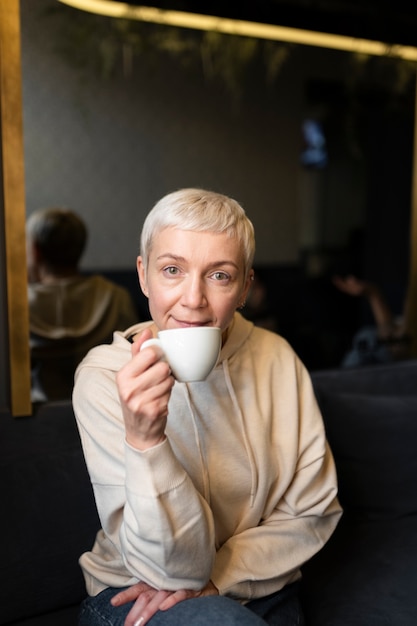 Mujer mayor bebiendo café durante una reunión