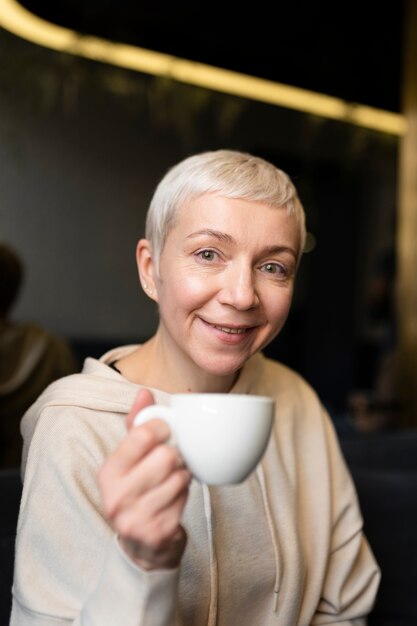 Mujer mayor bebiendo café durante una reunión