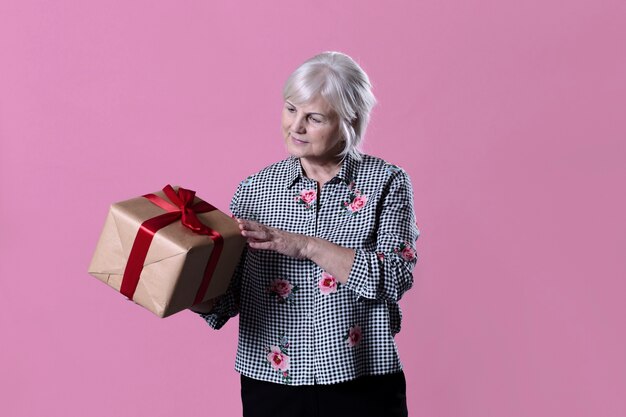 Mujer mayor con caja de regalo