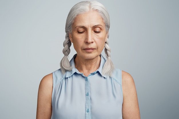 Mujer mayor con coletas vestida con blusa azul