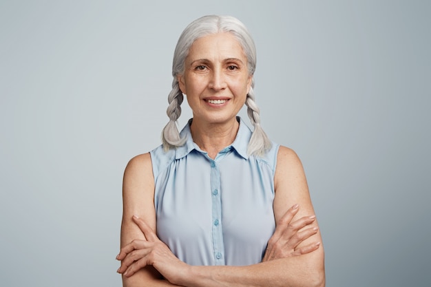 Foto gratuita mujer mayor con coletas vestida con blusa azul