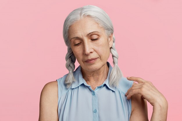 Mujer mayor con coletas vestida con blusa azul