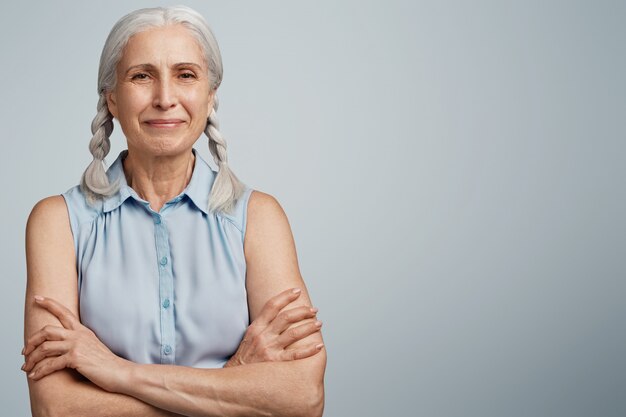 Mujer mayor con coletas vestida con blusa azul