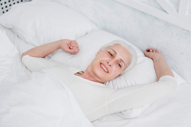 Mujer mayor despertándose en la cama