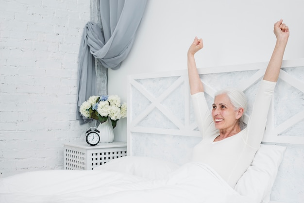 Mujer mayor despertándose en la cama