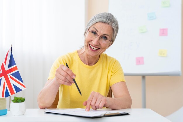 Mujer mayor enseñando lecciones de inglés en casa