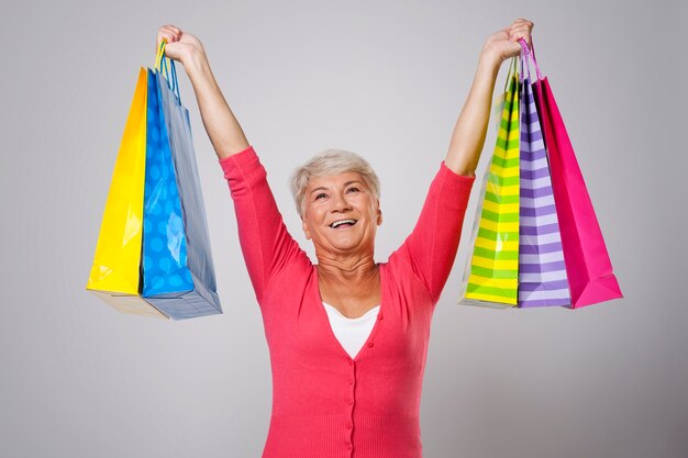 Mujer mayor feliz con bolsas de la compra.