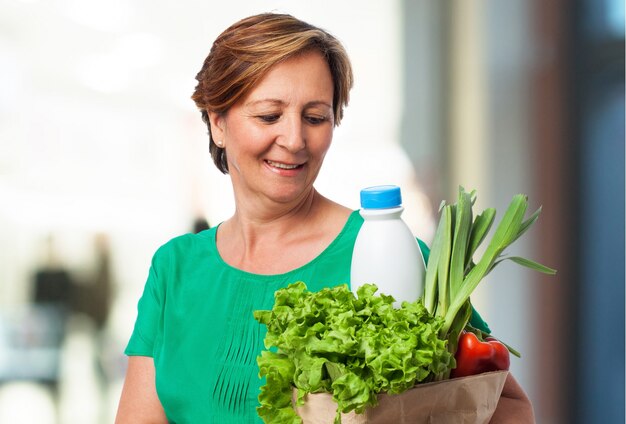 Mujer mayor feliz con la cesta de la compra