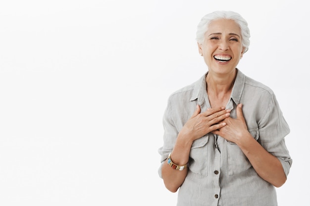 Mujer mayor feliz despreocupada con cabello gris riendo y sonriendo