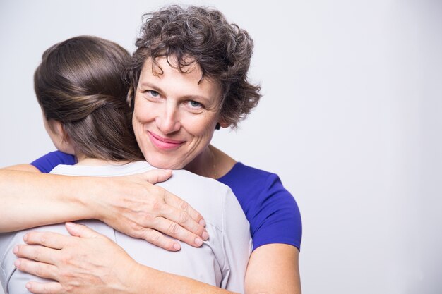 Mujer mayor feliz que abraza a la hija adulta joven