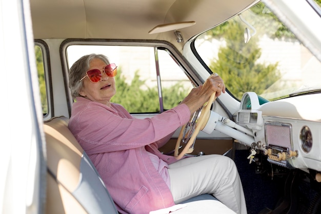 Mujer mayor feliz viajando sola en coche