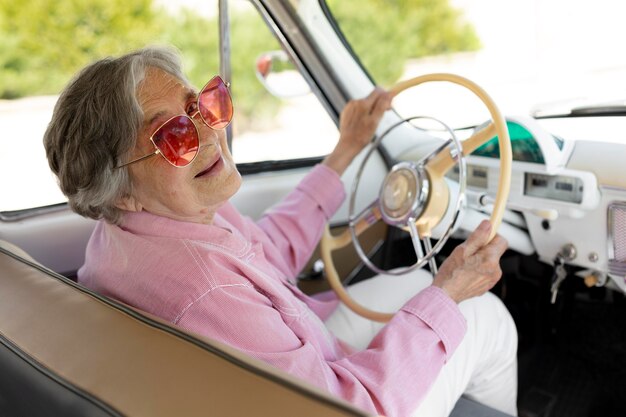 Mujer mayor feliz viajando sola en coche