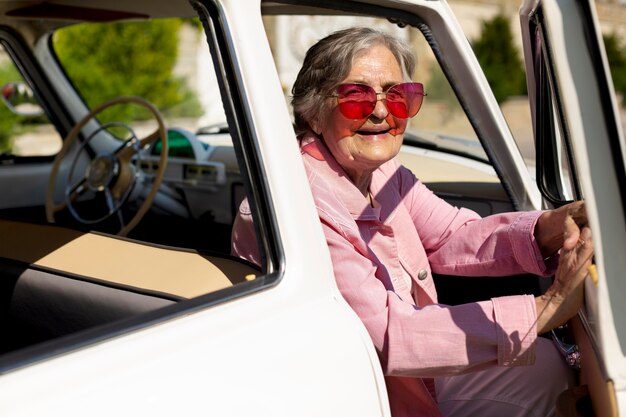 Mujer mayor feliz viajando sola en coche