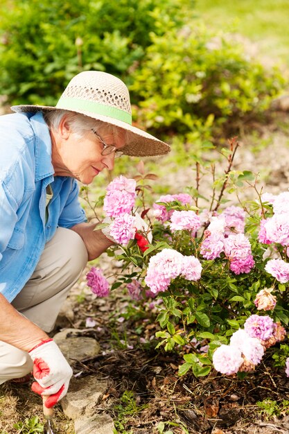 Mujer mayor, con, flores, en, jardín